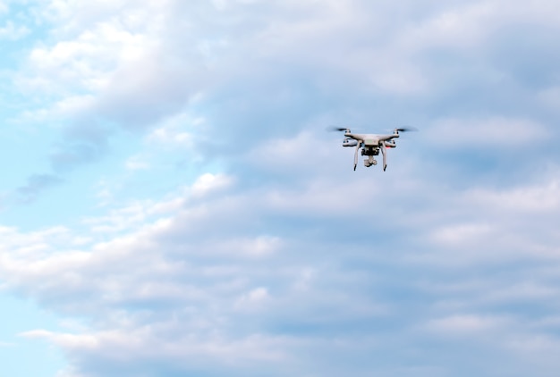 Drone Quadcopter con la cámara contra el cielo azul