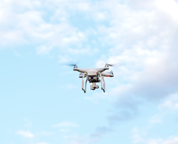 Drone Quadcopter con la cámara contra el cielo azul