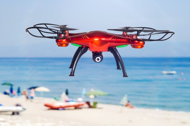 Drone rojo volando en la playa