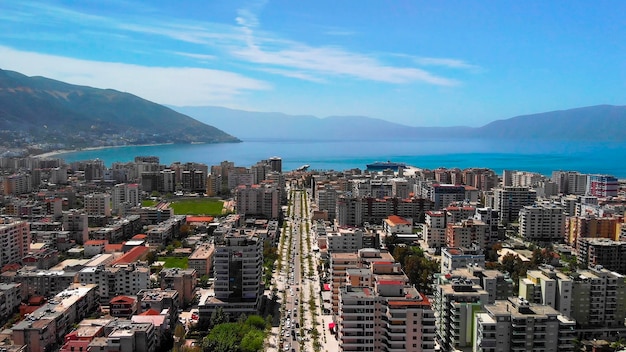 Drone shot da cidade em um dia ensolarado com árvores e água azul