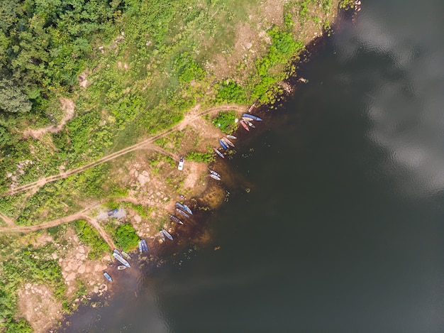 Drone shot vista aérea superior paisaje escénico el barco de pesca en un gran río con árbol verde fresco y playa