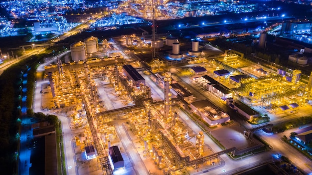 Drone de vista aérea del tanque de almacenamiento de petróleo con la planta de refinería de petróleo industrial de la fábrica de refinería de petróleo en el hermoso cielo atardecer y crepúsculo