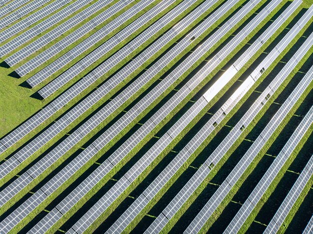 Drone vista de arriba hacia abajo de enormes campos de jardín y en la parte superior de los paneles solares en fila. concepto de energía renovable