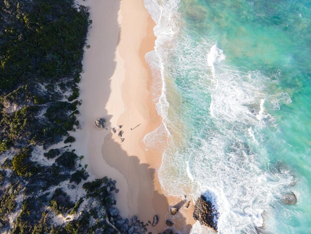 Drone vista de olas rodando desde el océano