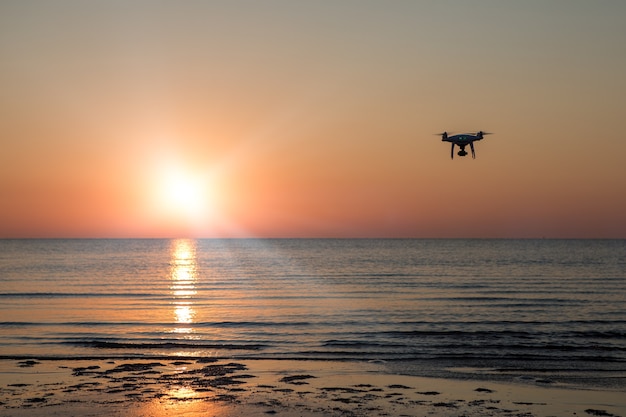 Foto drone voador em um fundo de pôr do sol no mar