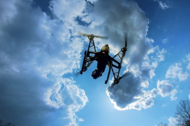 Drone voando em um céu azul brilhante. Nova tecnologia na fotografia aérea.