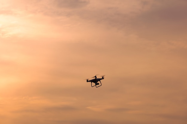 Drone voando no céu ao nascer do sol