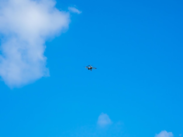 Drone voando no fundo do céu azul O drone está sendo controlado para permanecer no ar