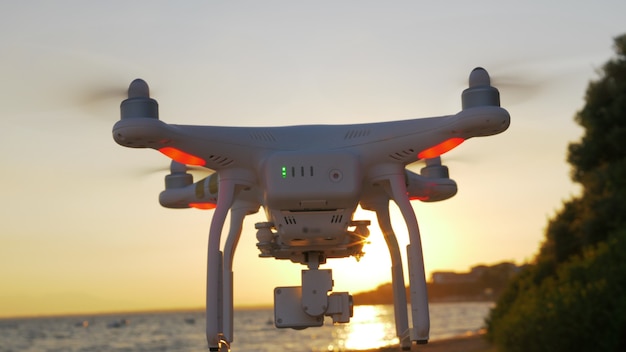 Drone volando cerca del mar al atardecer