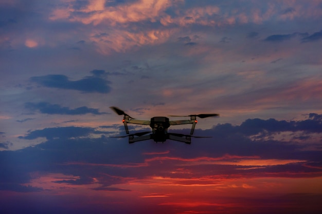 Drone volando sobre un cielo al atardecer con nubes de luz