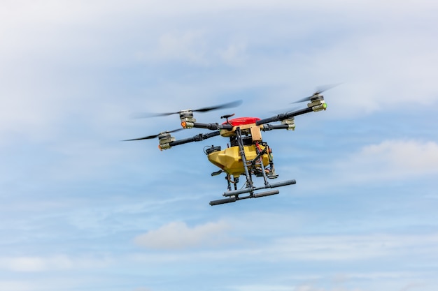 Los drones agrícolas se deslizan sobre los campos de arroz rociando fertilizantes. Los agricultores utilizaron un dron para rociar fertilizantes en los campos de arroz. Concepto de tecnología agrícola