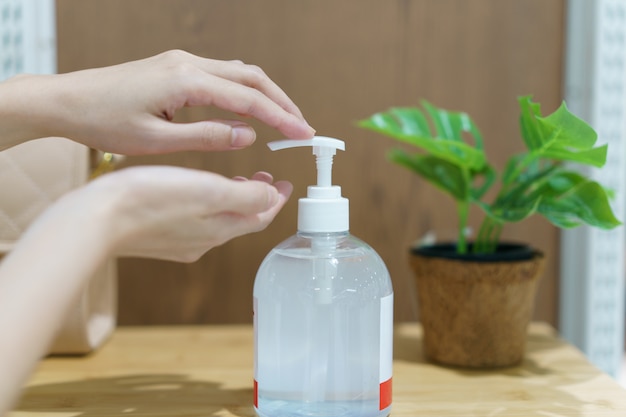 Drücken Sie die Desinfektionsflasche von Hand, um ihre Hand zu reinigen