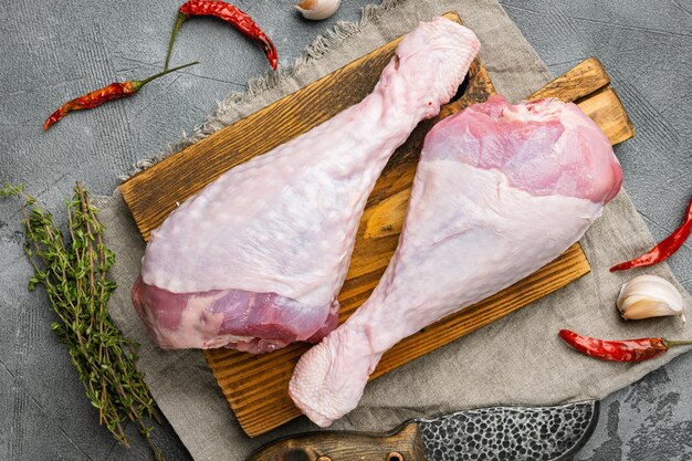 Drumstick Truthahnfleisch roh mit Zutatensatz, auf grauem Steintischhintergrund