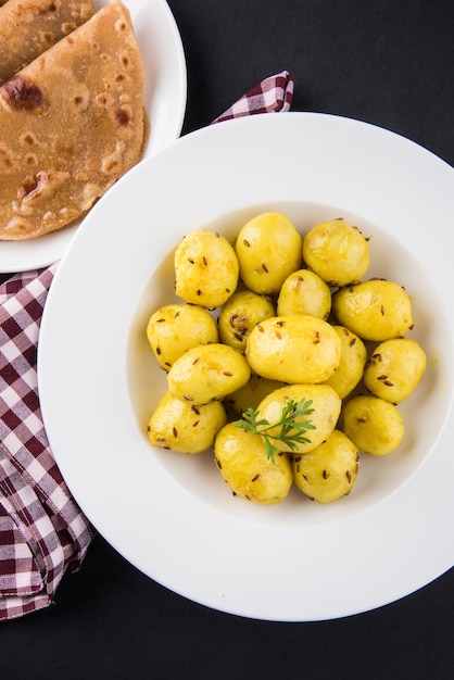 Dry Potato sabzi o Jeera Aloo fry es una receta india para el almuerzo o la cena que se sirve en un plato con Roti o paratha