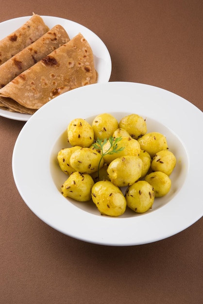 Dry Potato sabzi ou Jeera Aloo fry é uma receita indiana de almoço ou jantar servida em um prato com Roti ou paratha