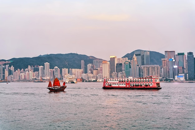 Dschunke im Victoria Harbour von Hongkong bei Sonnenuntergang. Blick von Kowloon auf HK Island.