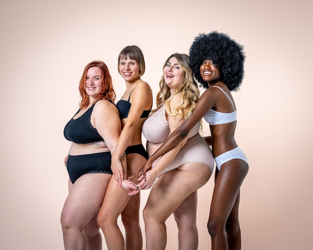 Foto du bist schön, egal wie du bist body positive und acceptance botschaft an eine vielfältige gruppe junger frauen, die in unterwäsche posieren und lächeln