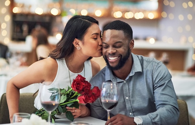 Du verdienst alle Knutschflecken der Welt Schnappschuss einer liebevollen jungen Frau, die ihren Freund in einem Restaurant auf sein Gesicht küsst