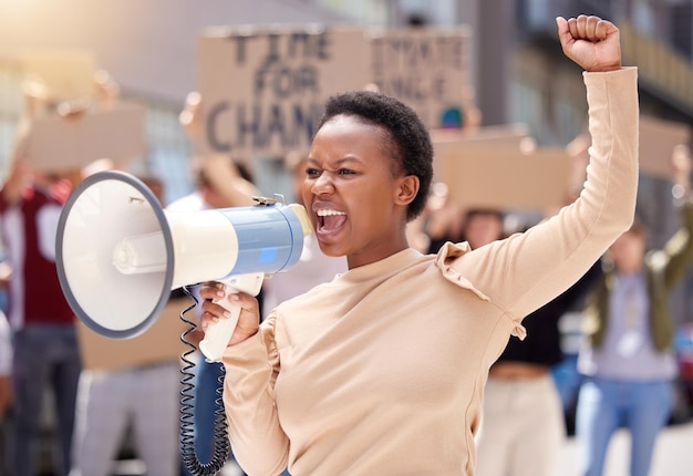 Du wirst uns niemals aufhalten Aufnahme einer jungen Frau, die durch ein Megafon einen Protest anschreit