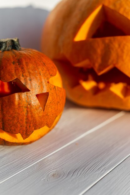 Duas abóboras assustadoras de Halloween em um fundo branco de madeira Feliz Halloween cores de outono