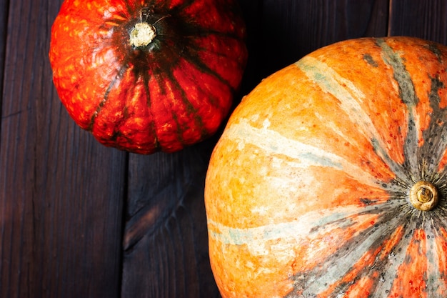 Foto duas abóboras laranja em uma mesa de madeira escura noite de halloween