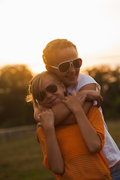 Foto duas adolescentes se divertem no parque. dois amigos ao ar livre. verão pessoas de óculos