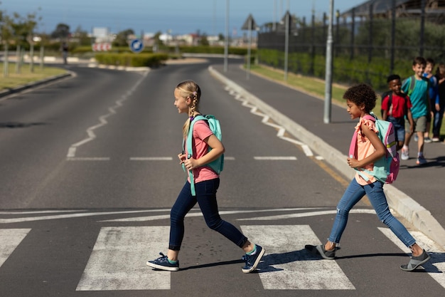 Duas alunas atravessando a rua em uma passagem para pedestres