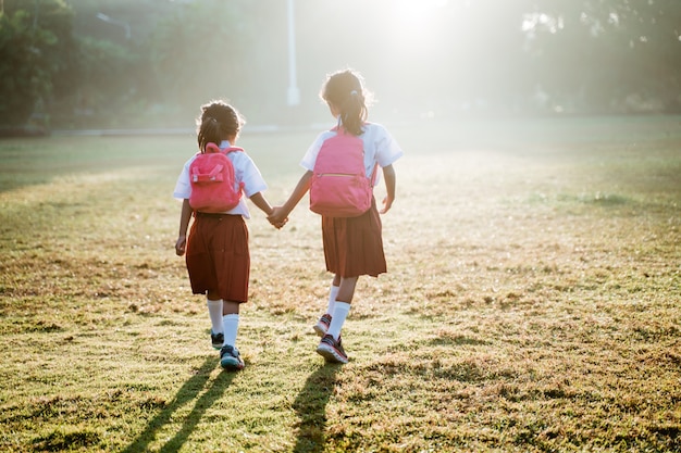 Duas amigas, aluna da escola primária caminhando juntas