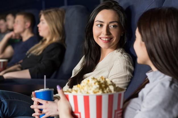 Duas amigas assistindo a um filme no cinema juntos