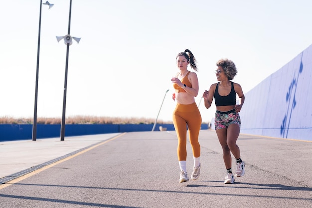 Duas amigas correndo em uma pista de atletismo