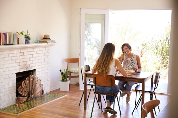 Duas amigas desfrutando de refeição em casa juntos