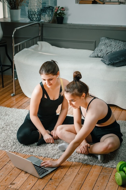 Duas amigas em casa conversando, sorrindo e praticando esportes