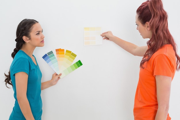 Foto duas amigas escolhendo cor para pintar uma sala
