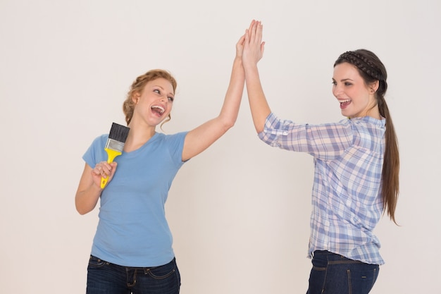 Duas amigas jovens e alegres que dão alta cinco