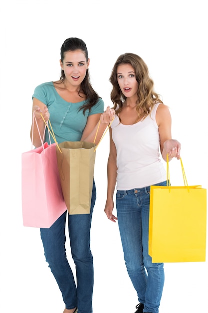 Duas amigas jovens e felizes com sacolas de compras