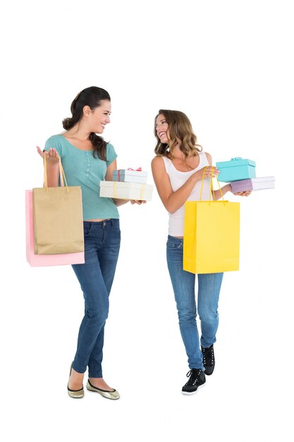 Duas amigas jovens e felizes com sacolas de compras