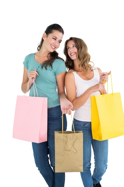 Duas amigas jovens e felizes com sacolas de compras