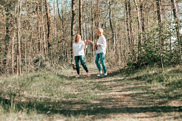 Duas amigas maduras estão caminhando pela floresta. Estilo de vida ativo, hobby