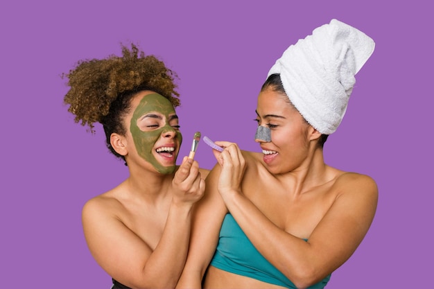 Duas amigas mimam-se com tratamentos faciais para um relaxante dia de spa em casa com risos e diversão Nutrindo a pele para um olhar brilhante e confiante