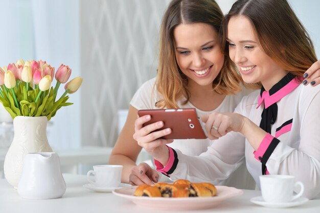 Duas amigas olhando para smartphone