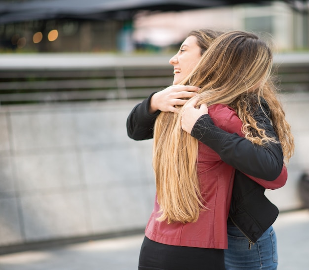 Foto duas amigas se abraçando ao ar livre