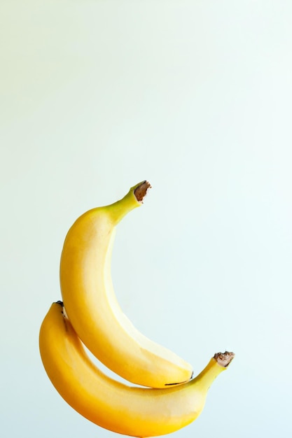 Duas bananas sensuais tocando uma na outra feliz levitação de frutas de banana em fundo branco