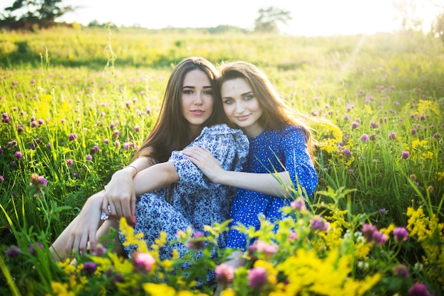 Duas belas garotas europeias em um campo de flores silvestres