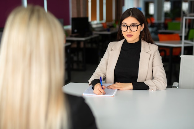 duas belas moças no escritório à mesa