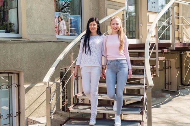 duas belas mulheres descem as escadas da loja