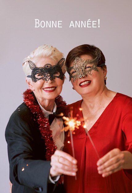 Duas belas mulheres maduras e elegantes em máscaras de carnaval com brilhos celebrando o ano novo.