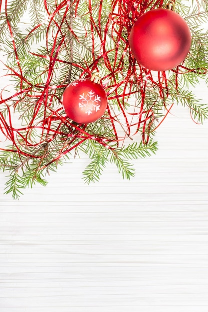 Duas bolas vermelhas de Natal e galho de árvore em papel em branco
