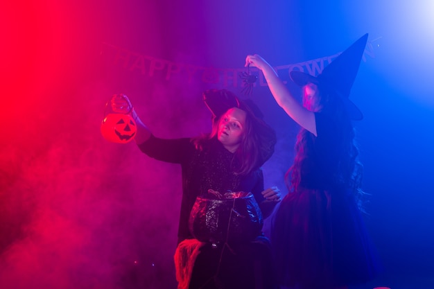 Duas bruxas de halloween fazendo uma poção e conjurando na noite de halloween, feriados mágicos e místicos