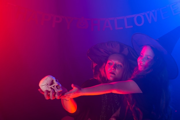 Foto duas bruxas de halloween fazendo uma poção e conjurando na noite de halloween, feriados mágicos e místicos