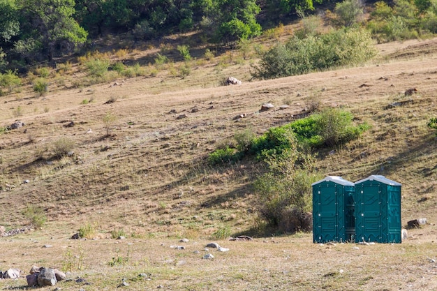 Duas cabines de plástico azul de armários secos em um parque natural copiam o espaço